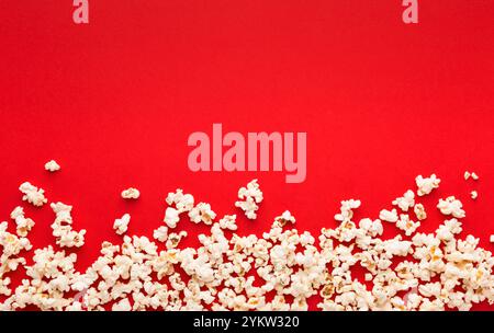 Popcorn aus Schiefer, verstreut auf rotem Hintergrund, Draufsicht Stockfoto