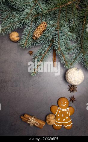 Ein Geschenk für die Feiertage. Grußkarte mit Platz für Text. Weihnachtsbaumzweige, Lebkuchenmann, Kegel, Zimtstangen, Weihnachtsbaumsterne und Stockfoto