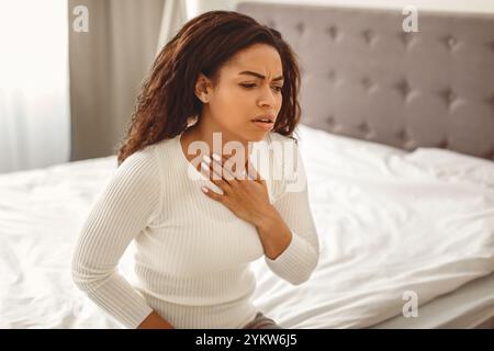 Junge schwarze Frau hustet, leidet an Halsschmerzen Stockfoto