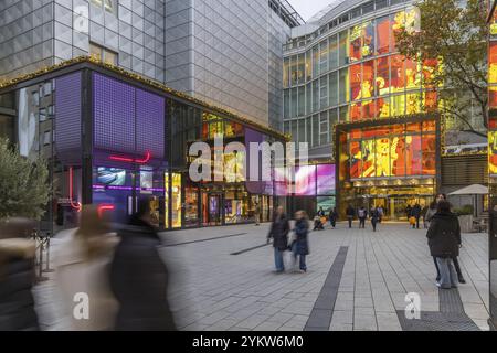 Porsche Brand Store und Breuninger Kaufhäuser am Abend. Geschäfte mit Logos im Dorotheen Quartier, DOQU. Leute mit Einkaufstaschen an Stockfoto