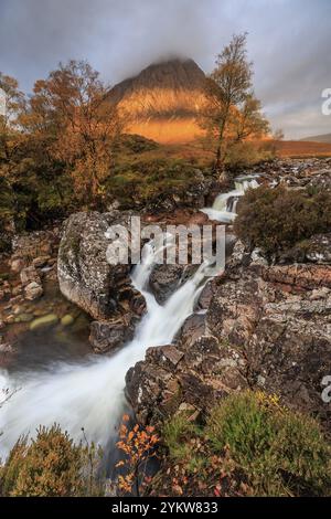 Wilder Fluss, Wasserfall, Herbstfarben, Morgenlicht, Berglandschaft, bewölkte Stimmung, Buachaille Etive Mor, Glencoe, Scottish Highlands, Schottland, G Stockfoto