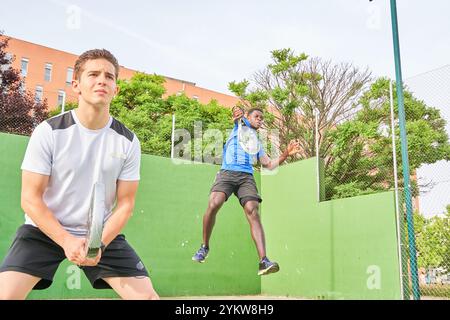 Zwei junge Freunde spielen Paddeltennis auf einem Platz. Sportkonzept. Kopierbereich Stockfoto