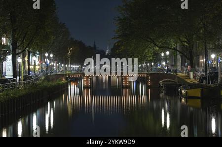 Ein Bild einer Kanalbrücke, beleuchtet bei Nacht, in Amsterdam Stockfoto