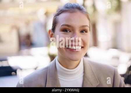 Eine lächelnde junge Frau in einem stilvollen und schicken Ambiente, das Selbstvertrauen und Charme ausstrahlt Stockfoto