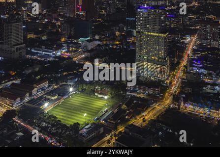 Ein Bild des EV Arena Kelab Sultan Sulaiman Fußballfeldes und des Tamu Hotel and Suites Kuala Lumpur bei Nacht Stockfoto