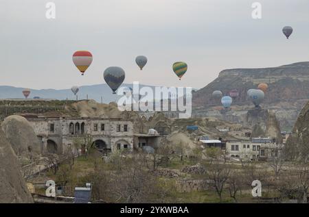 Ein Bild von Heißluftballons, die bei Sonnenaufgang über den Goreme Historical National Park und die Stadt Goreme fliegen Stockfoto