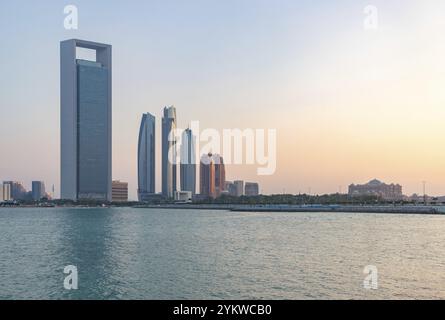 Ein Bild der Etihad Towers, des Hauptsitzes der Abu Dhabi National Oil Company und des Emirates Palace Mandarin Oriental Hotel bei Sonnenuntergang Stockfoto