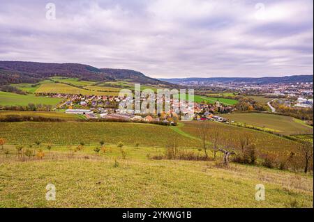 Hügelige Herbstlandschaft mit Dorf und Feldern unter bewölktem Himmel, Kunitz, Thüringen, Deutschland, Europa Stockfoto