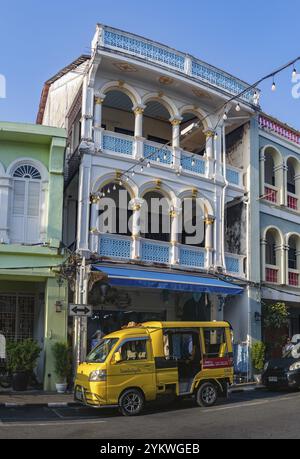 Ein Bild eines gelben Tuk Tuk vor der farbenfrohen chinesisch-portugiesischen Architektur in der Altstadt von Phuket Stockfoto