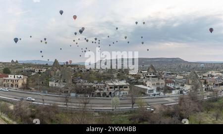 Ein Bild von Heißluftballons, die bei Sonnenaufgang über den Goreme Historical National Park und die Stadt Goreme fliegen Stockfoto