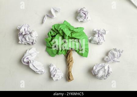 Draufsicht von grünem zerknittertem Papier in Form eines Baumes. Umweltverschmutzungskonzept Stockfoto
