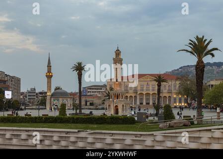 Ein Bild des Konak-Platzes bei Sonnenuntergang, mit dem Uhrturm von Izmir, der Konak-Moschee und dem Gouvernementgebäude von Izmir Stockfoto