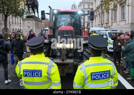 London, Großbritannien. November 2024. Polizeibeamte stehen um einen Traktor, der kurz zuvor in Whitehall über ein Straßenschild gefahren ist. Tausende von Landarbeitern und Unterstützern nahmen an einer Demonstration gegen neue Erbschaftssteueränderungen Teil, die im Herbstbudget von Rachel Reeves angekündigt wurden. Quelle: Eleventh Photography/Alamy Live News Stockfoto