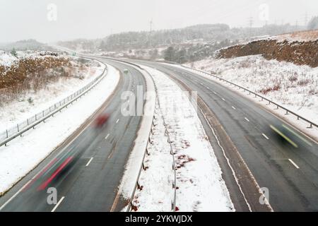 Lange Belichtungsbewegung Verkehrsunschärfe auf der A465 in Ebbw Vale während eines Winterschneesturms Stockfoto