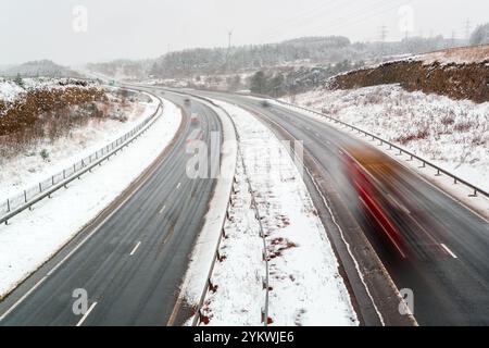 Bewegungsunschärfe lange Belichtung der A465-Straße während eines Winterschneesturms Stockfoto