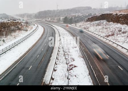 Lange Belichtungsbewegung Verkehrsunschärfe auf der A465 in Ebbw Vale während eines Winterschneesturms Stockfoto