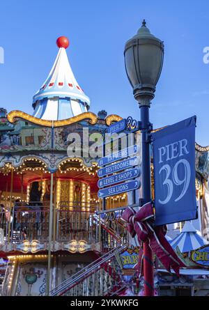 Ein Bild der Schilder des Pier 39 neben dem berühmten farbenfrohen Karussell Stockfoto