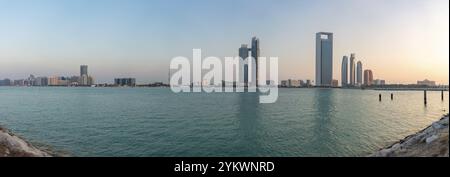 Ein Bild der Abu Dhabi Beach Front, von der anderen Seite des Wassers gesehen, bei Sonnenuntergang, mit der St. Regis Abu Dhabi Hotel, die Etihad Towers und das Abu DHA Stockfoto