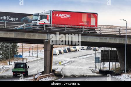 Ein schneebedecktes Ende des Tages auf der M62, als sie den höchsten Teil ihrer Länge in den Pennines zwischen Rochdale und Huddersfield überquert. Die M62 ist eine 107 Meilen (172 km) lange Trans-Pennine-Autobahn in Nordengland, die Liverpool und Hull über Manchester, Bradford, Leeds und Wakefield verbindet. Stockfoto