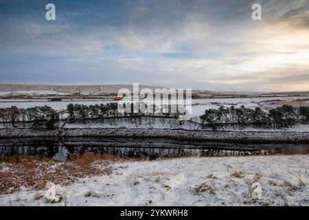 Ein schneebedecktes Ende des Tages auf der M62, als sie den höchsten Teil ihrer Länge in den Pennines zwischen Rochdale und Huddersfield überquert. Die M62 ist eine 107 Meilen (172 km) lange Trans-Pennine-Autobahn in Nordengland, die Liverpool und Hull über Manchester, Bradford, Leeds und Wakefield verbindet. Stockfoto