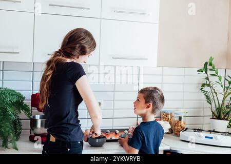 Mom und Sohn kochen Kuchen in der Küche Stockfoto