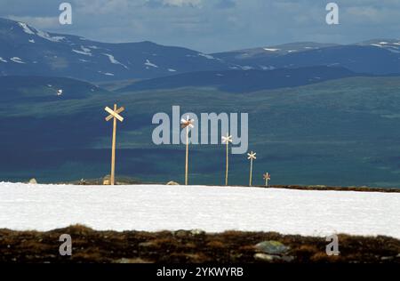 Wegmarkierungen, Schilder, Kreuz auf einem Holzpfosten, um während der Winteraktivitäten zu folgen. Wandern auf Skiern oder mit dem Schneemobil. Stockfoto