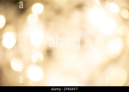 Goldener brauner Weihnachtsbokeh-Hintergrund. Verschwommene weiße Girlande Lichter Hintergrund mit Glitzern und sanften Reflexionen für das Rendering, Grußkarten Stockfoto