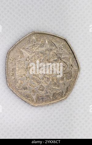 Ein Nahbild zeigt eine britische 50-Pence-Münze aus dem Jahr 1973 mit einem Design strahlender Sterne. Die Münze ist silberfarben und weist Gebrauchsspuren auf. Stockfoto