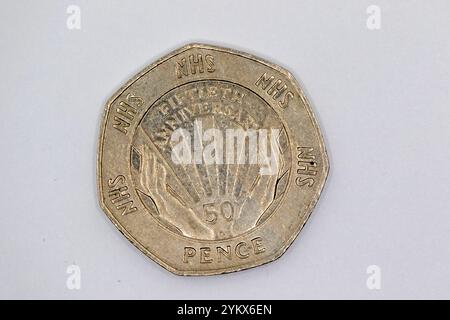 Eine 50-Pence-Münze zum 50. Jahrestag des NHS. Die Münze hat ein zentrales Design mit zwei Händen, die einen Sonnenstrahl umhüllen, umgeben von der Stockfoto