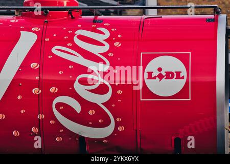 Nahaufnahme eines hellroten zylindrischen Objekts, möglicherweise eines Tankers, mit „Cola“ in weißer Schrift und dem Lidl-Logo. S Stockfoto