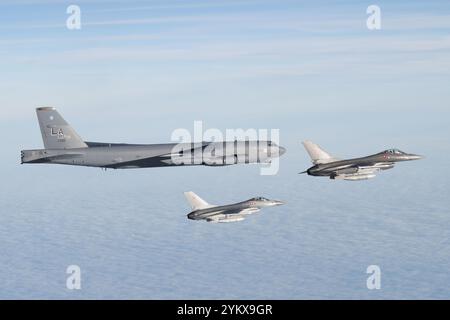 Eine B-52H Stratofortress der US Air Force, die der 20th Expeditionary Bomb Squadron zugeordnet ist, wird von zwei Royal Danish Air Force F-16 Kampffalken eskortiert Stockfoto