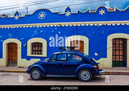 Der blaue Volkswagen Käfer parkte vor dem bezaubernden blauen Kolonialgebäude in San Cristobal de las Casas, Chiapas, Mexiko Stockfoto