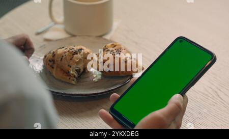 Zurück Ansicht nicht erkennbarer Guy man männlicher Kunde Besucher Café Restaurant Essen Mittagessen Kaffee auf Tisch Halten Handy zahlen Rechnung online Lebensmittel Lieferung kaufen Stockfoto