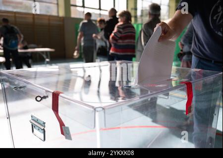 Die Hand des Wählers, die die Stimme in die Wahlurne bringt. Die Aufschrift auf dem Siegel im polnischen „Wahlsiegel“ Stockfoto