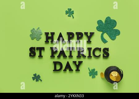 Worte HAPPY ST PATRICKS DAY mit einem Topf mit goldenen Münzen und Kleeblättern auf grünem Hintergrund Stockfoto