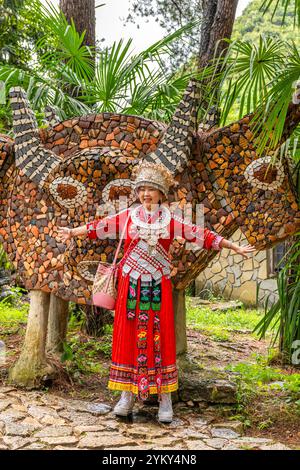 GUIZHOU, GUIYANG, CHINA, 16. AUGUST 2022: Eine Frau, die traditionelle Miao-Kleidung trägt, im Yelang-Tal, einem magischen Ort voller Steinburgen, Türme Stockfoto