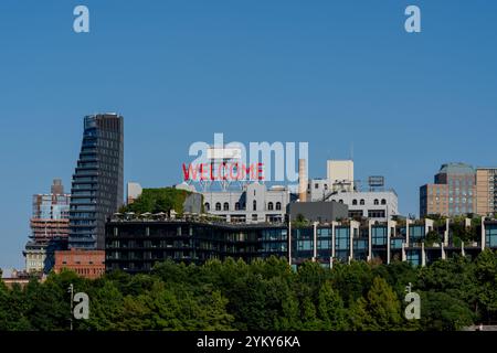 Ein rotes WILLKOMMENSSCHILD auf einem Gebäude in Brooklyn Heights in New York City vom East River aus gesehen. Stockfoto