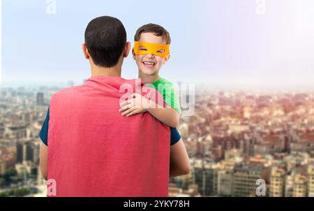 Glücklicher, liebevoller Vater. Papa und sein Sohn spielen draußen. Vater und Junge verkleidet als Superhelden. Vatertag Konzept. Stockfoto