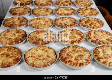 Frisch gebackene Brötchen ordentlich auf dem Tisch in der Bäckereiküche angeordnet Stockfoto