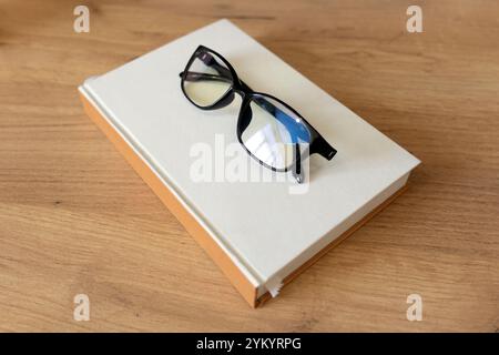 Brillen und Bücher auf dem Tisch im Wohnzimmer. Bildungskonzepte und Wissen Stockfoto