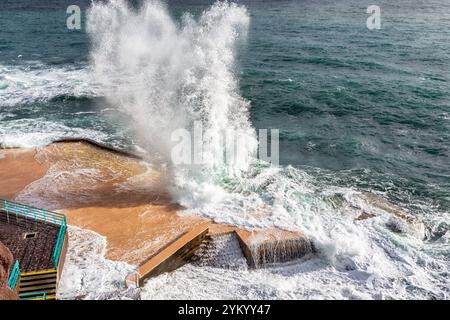 Ein atemberaubender Blick auf die Wellen, die dramatisch gegen die Küstenstrukturen in Funchal, Madeira, prallen und die raue Schönheit des Atlantischen Ozeans zeigen Stockfoto