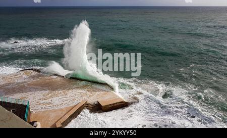 Ein atemberaubender Blick auf die Wellen, die dramatisch gegen die Küstenstrukturen in Funchal, Madeira, prallen und die raue Schönheit des Atlantischen Ozeans zeigen Stockfoto