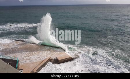 Ein atemberaubender Blick auf die Wellen, die dramatisch gegen die Küstenstrukturen in Funchal, Madeira, prallen und die raue Schönheit des Atlantischen Ozeans zeigen Stockfoto