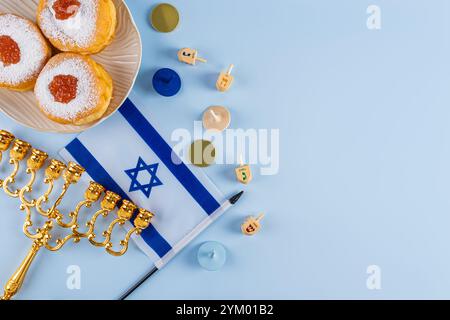 Traditionelle Leckereien und Symbole für den jüdischen Feiertag von Hanukka. Obere Ansicht. Blauer Hintergrund. Eine Kopie des Bereichs Stockfoto