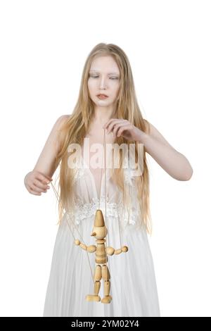 Ein junger weiblicher Puppenspieler manipuliert einen hölzernen Mann auf weißem Hintergrund Stockfoto