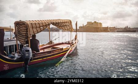 Dghajsa, traditionelles maltesisches Wassertaxi mit Fort St. Angelo im Hintergrund Stockfoto