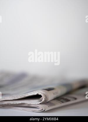 Gefaltete Zeitungen auf einem Tisch vor hellem Hintergrund mit geringer Schärfentiefe. Platz für Text über Zeitungen Stockfoto