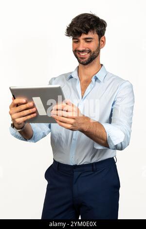 Geschäftsmann lächelt, während er ein digitales Tablet verwendet, isoliert auf weißem Hintergrund Stockfoto