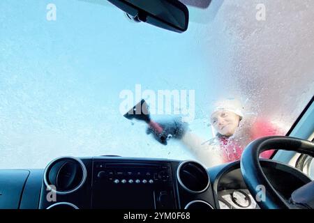 Dunsford, Devon, Großbritannien. November 2024. Raich Keene kratzt Eis von einer gefrorenen Windschutzscheibe in Dunsford, Devon. Hinweis: Nidpor/Alamy Live News Stockfoto