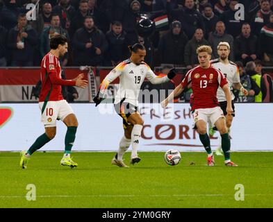 Budapest, Ungarn. November 2024. Leroy Sane aus Deutschland tritt 2024/25 am 19. November 2024 in Budapest in der ungarischen Puskas Arena gegen Andras Schafer (r) und Dominik Szoboszlai (l) um den Ball an. Quelle: Laszlo Szirtesi/Alamy Live News Stockfoto